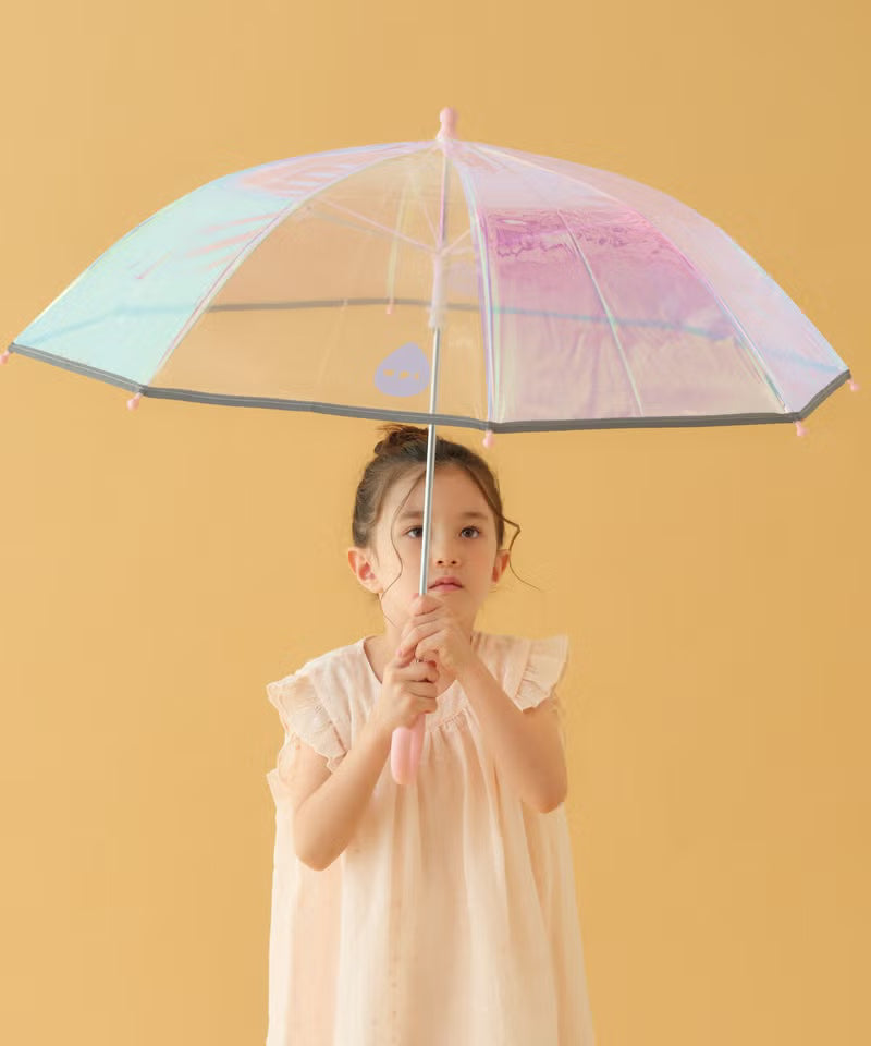Young girl holding a transparent umbrella with a colorful pattern against a yellow background