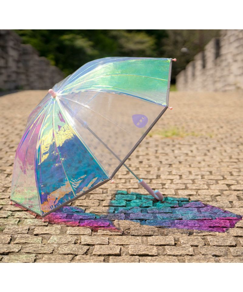 rainbow shiny kids umbrella on the paved floor under the sun