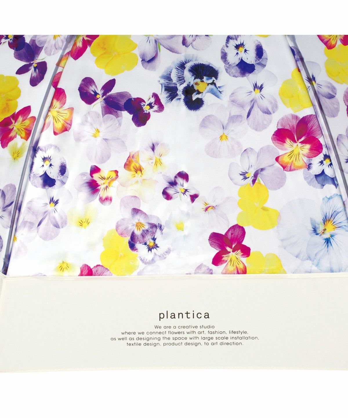 Close-up of the limited edition Wpc x Plantica Joyful Floral umbrella in the Purple pansy pattern, featuring the plantica logo